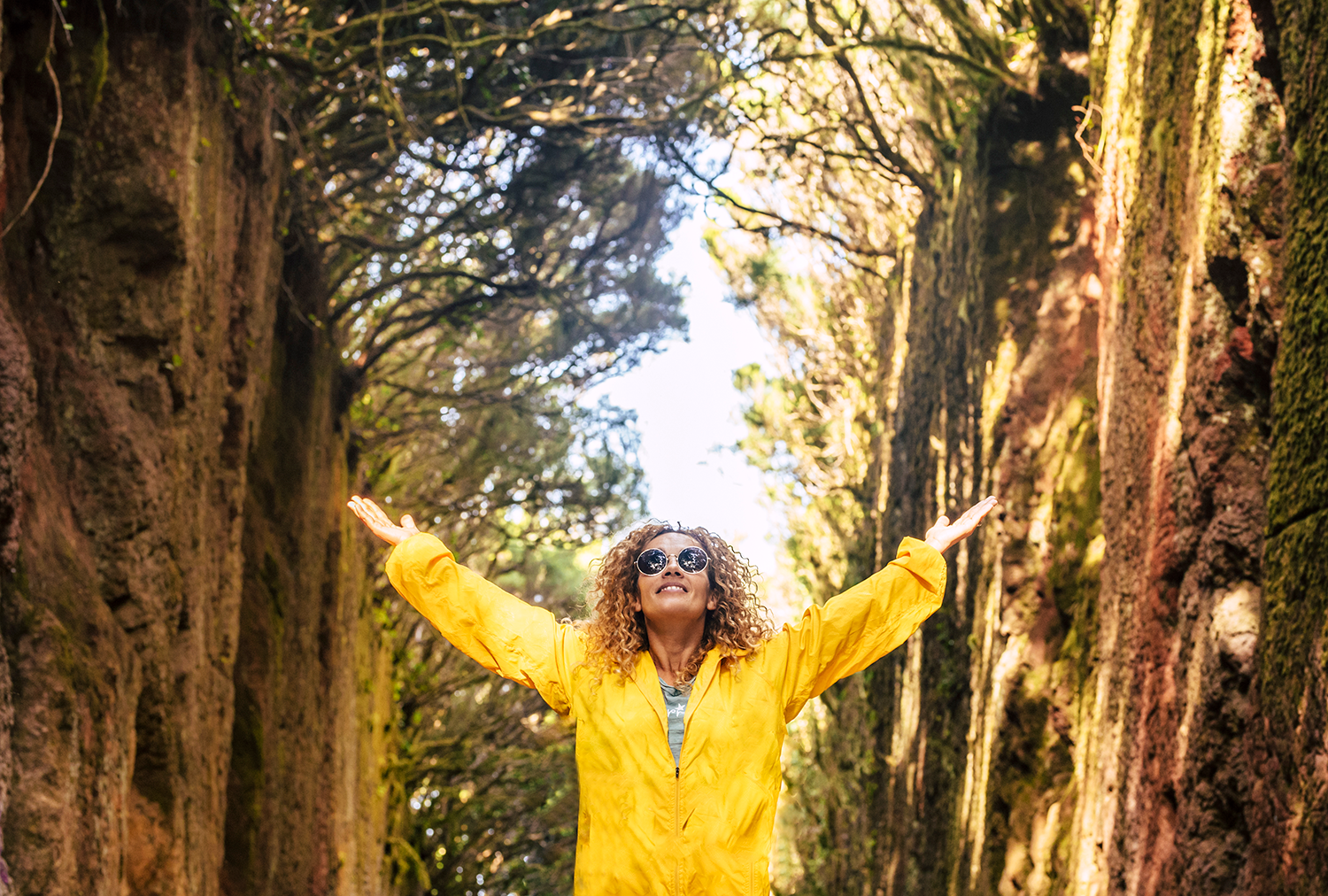 An image of a joyful woman, hands raised, framed by trees, in a blog post by Bay Area Endocrinology about Thyroid Nodules.